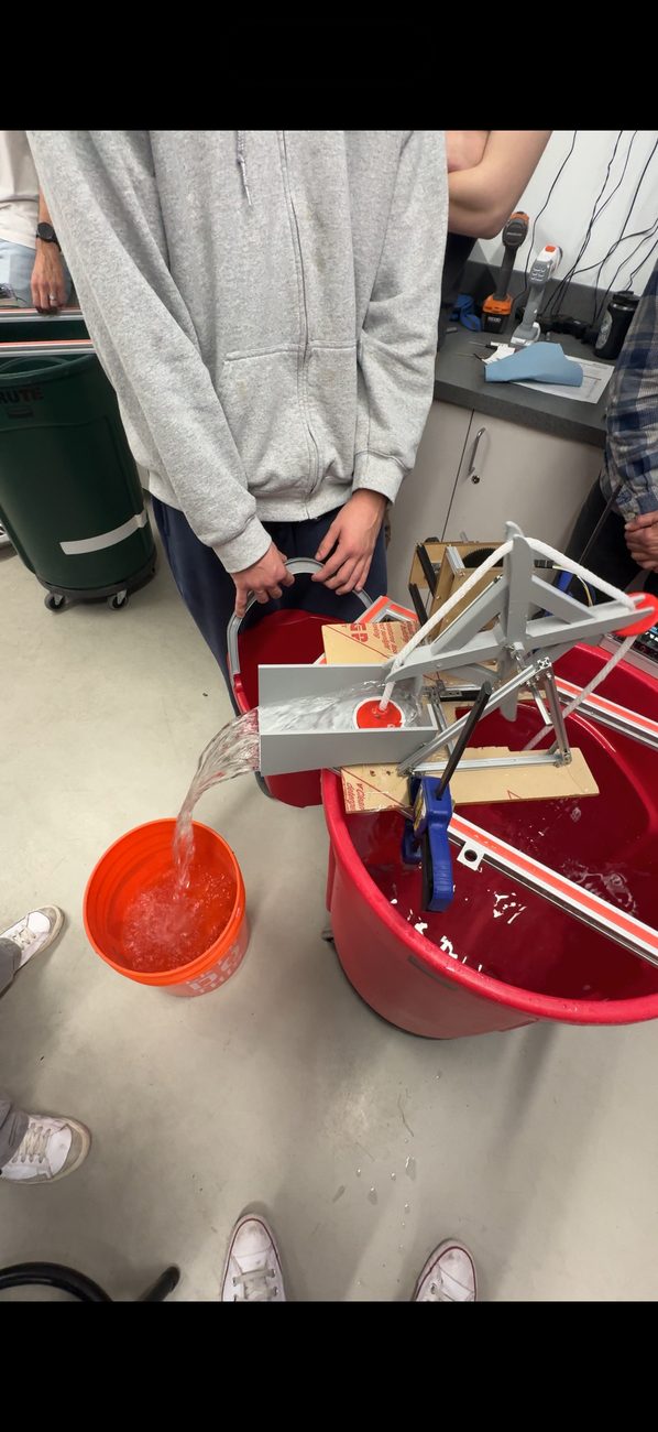 Sustainable water pump prototype moving water into a bucket during testing